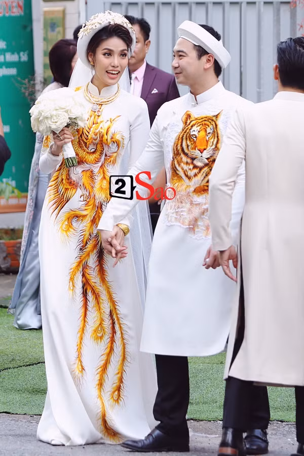 Lan Khuê rạng rỡ trong thiết kế áo dài thêu phượng quý phái, sang trọng. Thêm vào đó, siêu mẫu còn kết hợp với mấn đội đầu kiểu dáng ấn tượng, làm điểm nhấn sáng cho cả set đồ. Ảnh: 2sao.