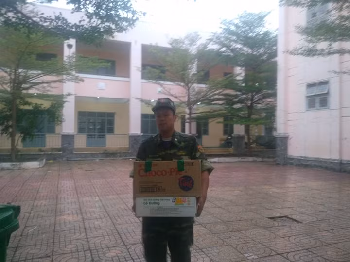 Các anh bộ đội đang bưng thức ăn để chuẩn bị cho bữa cơm tối cho người dân trước thềm con bão. 