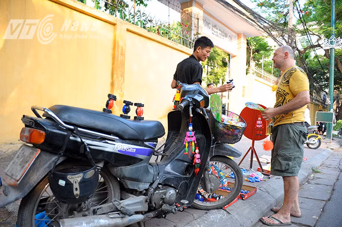 Chiếc xe Suzuki cà tàng, cũ kĩ vừa là phương tiện vận chuyển, vừa là sạp hàng bày bán đồ chơi của David.
