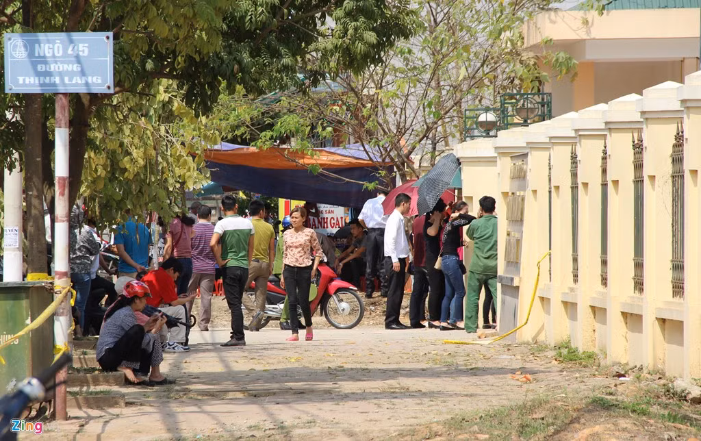 Hàng chục người nhà các bị cáo đội nắng, đứng ngoài cổng tòa theo dõi phiên xử qua hệ thống loa phát thanh.