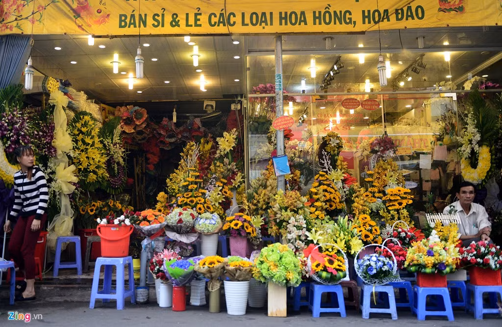 Những bó hoa được cắm sẵn bày thành hàng dọc bán ngay dưới lề đường.