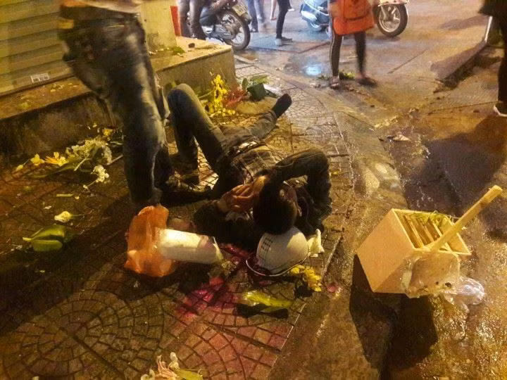 Một nạn nhân vụ đâm ô tô ngất xỉu nằm sóng soài trên vỉa hè.