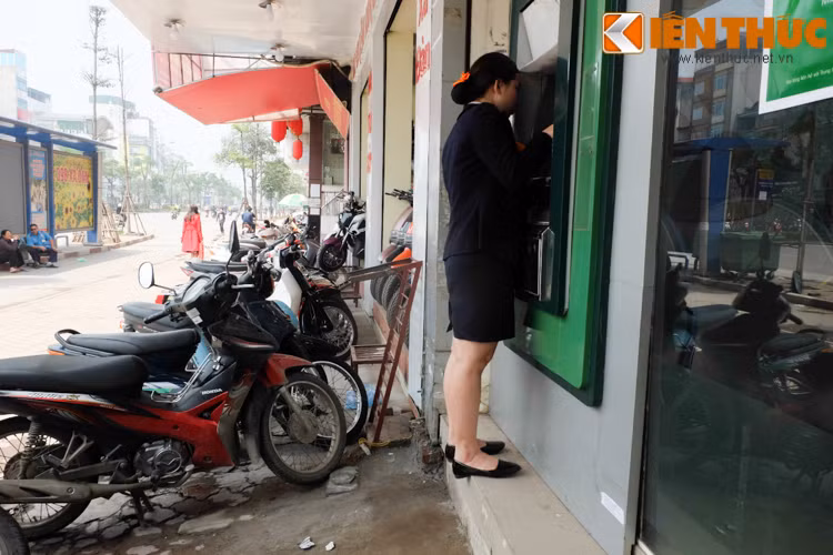 Vì màn hình hiển thị ở trên cao và bị lóa sáng, khó theo dõi thông tin nên cô gái này phải trèo lên phần bậc trước cây ATM để rút tiền.