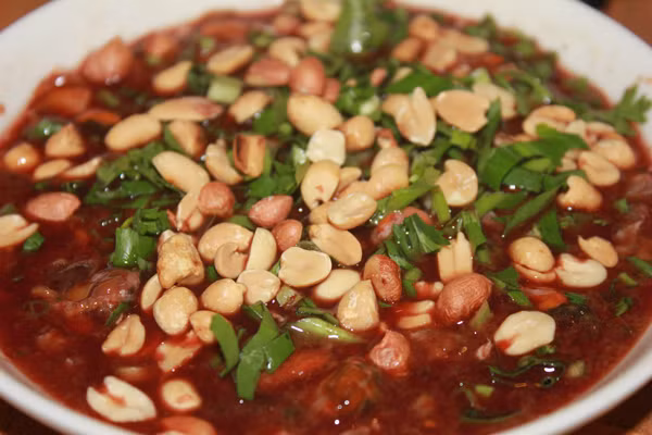 Cuối cùng, người ta rưới số tiết dơi đều khắp thịt dơi bằm xào chín rồi rắc ngò gai bằm nhỏ cùng đậu phộng rang bóc bỏ vỏ và những lát ớt sừng trâu đỏ tươi đều khắp trên mặt dĩa tiết canh dơi, thật hấp dẫn trước khi dọn ra bàn.
