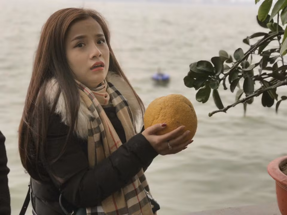 ... thì bỗng nhiên khuôn mặt biến sắc khi thấy quả bưởi bất ngờ rụng và rơi vào lòng bàn tay mình.