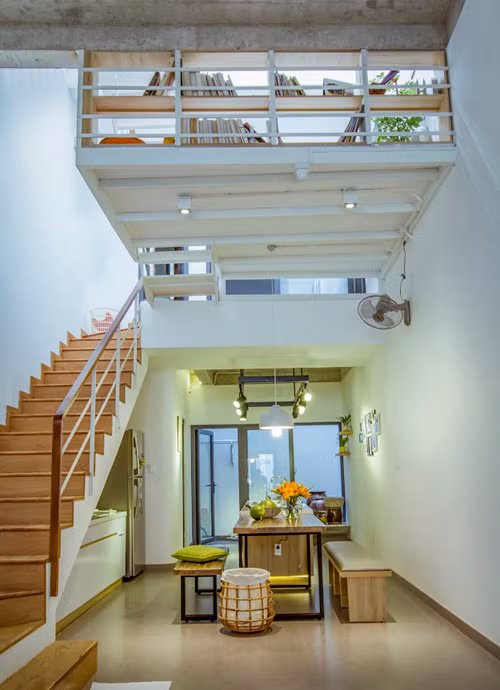 Cầu thang bố trí sát tường nhằm giúp lối đi thông thoáng. Gầm cầu thang được tận dụng để thiết kế bếp.