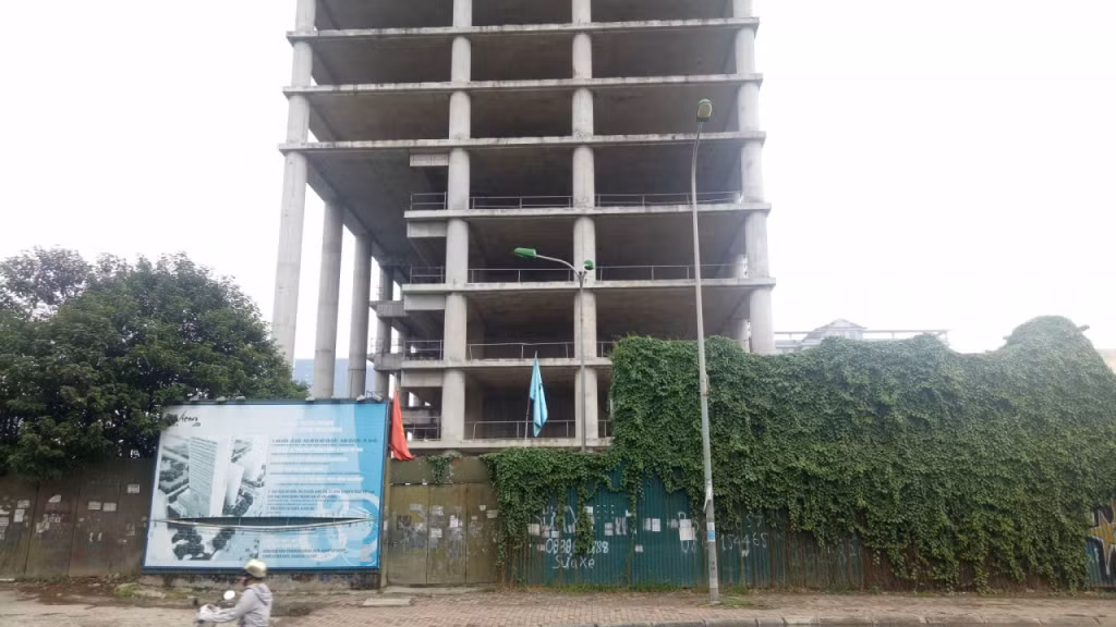 Sau nhiều năm bỏ hoang, cỏ mọc um tùm xung quanh toà tháp cao tầng Vicem Tower. Ảnh: SKCĐ.
