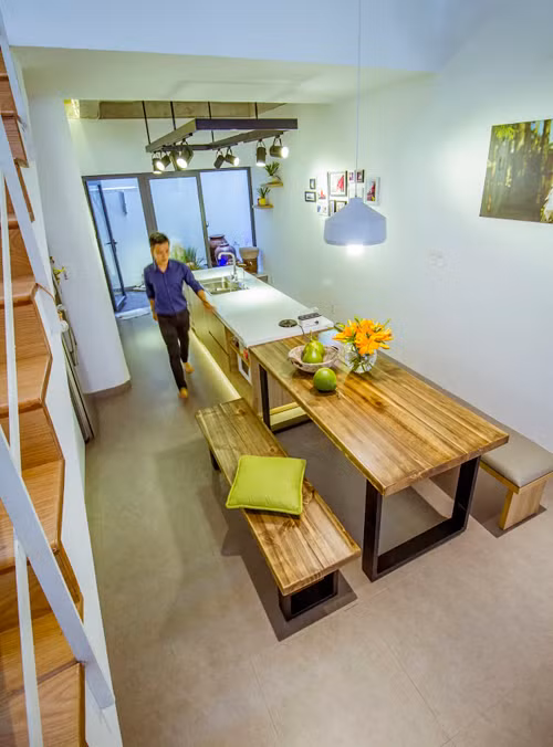 Đảo bếp và bàn ăn được bố trí ở giữa nhà để tiện cho việc thao tác, chế biến và ăn uống.