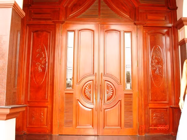 Do mặt tiền thường xuyên tiếp xúc với ánh nắng mặt trời và sự tác động của thời thiết nên các mẫu cửa gỗ tự nhiên thường được chọn nhiều hơn. Ảnh: Lancan.