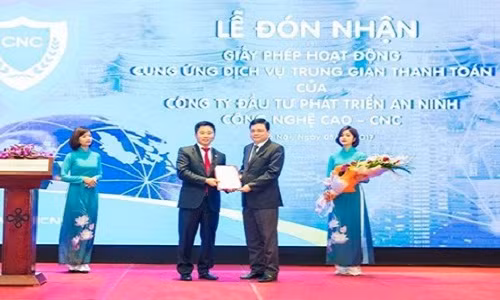 Nguyễn Văn Dương (cà vạt đỏ) đại diện CNC nhận quyết định trao giấy phép hoạt động cung ứng dịch vụ trung gian vào tháng 4/2017. Ảnh: Baodatviet.