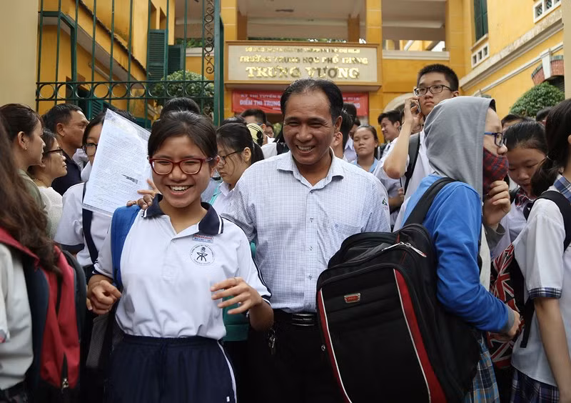 Đúng 10 giờ, môn thi đầu tiên kết thúc. Một học sinh tươi cười khoe với bố làm bài rất tốt tại điểm thi THPT Trưng Vương, quận 1.