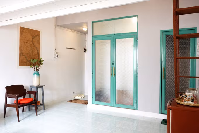 Phía sau hai cánh cửa sơn xanh là không gian lưu trữ quần áo.