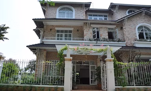 Tọa lạc ở quận 7, TP HCM, căn biệt thự 3 tầng khiến người qua đường phải chú ý bởi vẻ đẹp mộc mạc. Toàn bộ tường bên ngoài là gach trần, không sơn, không trát.