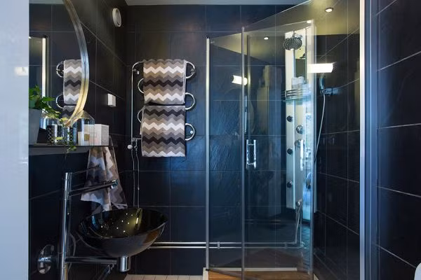 Phòng tắm sử dụng gam màu tối càng tăng thêm sự sang trọng của căn hộ mini. Nguồn ảnh: Homedit.