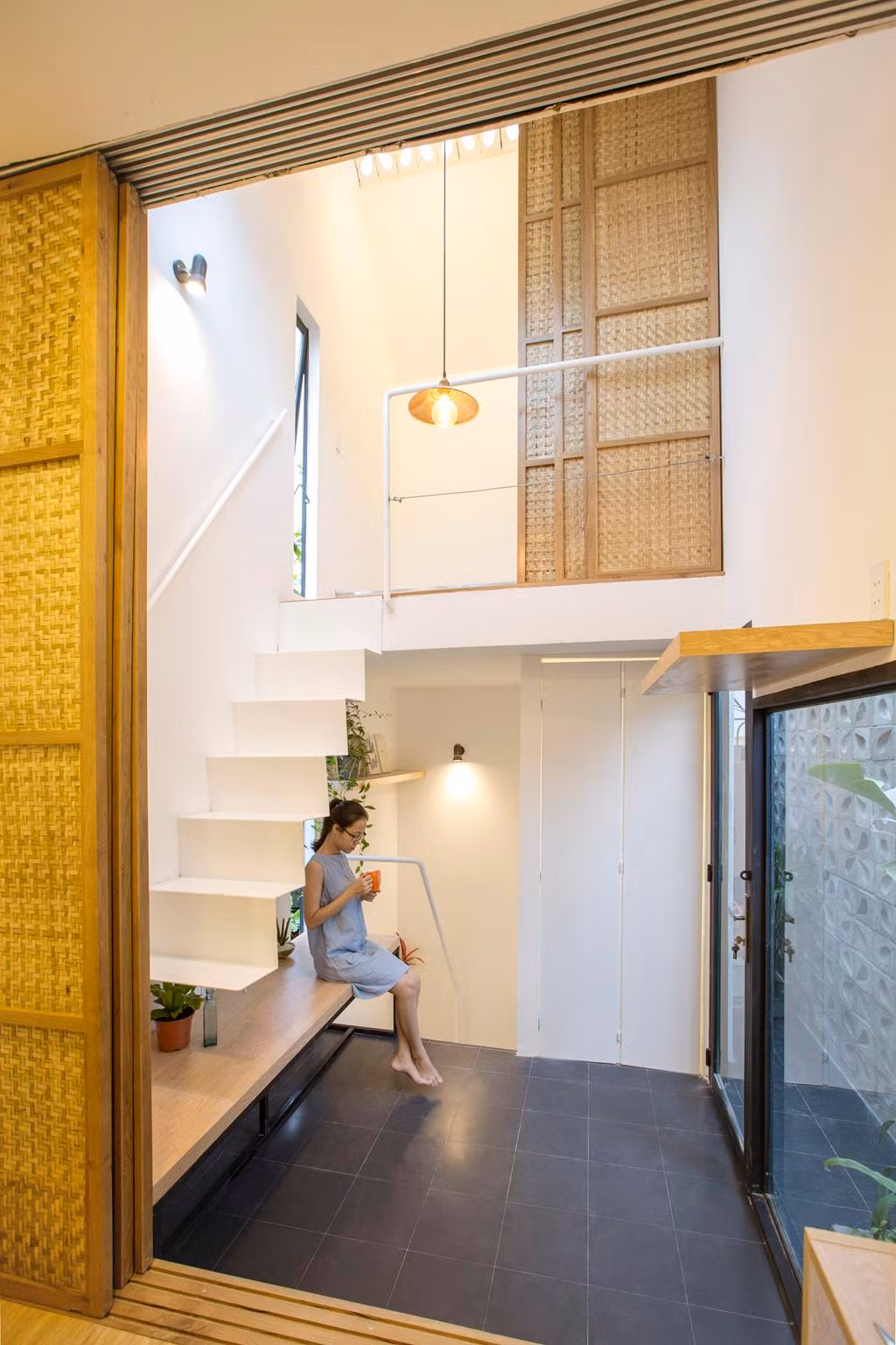 Cửa kính lớn và tường gạch lỗ phía trước giúp ngôi nhà nhận nhiều ánh sáng.