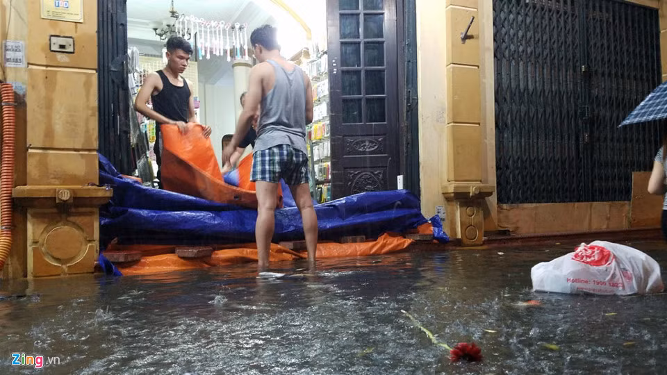 Các ngôi nhà gần khu vực Đại học Sư phạm Hà Nội, cánh đàn ông hì hục che chắn, be bờ ngăn nước tràn vào nhà.