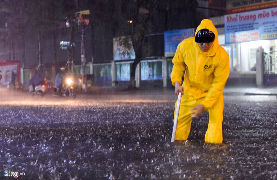 Công nhân thoát nước có mặt kịp thời dọn rác trôi làm tắc cống nhưng do cơn mưa lớn, phố Thái Hà vẫn bị ngập sâu trong vài giờ.