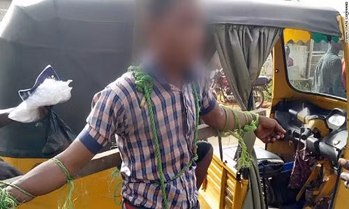 Em học sinh nam bị trói và đánh chỉ vì đi học muộn. Ảnh: CNN.