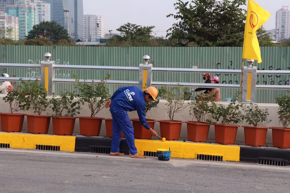 Công nhân đang gấp rút hoàn thành công việc sơn tại dải phân cách.
