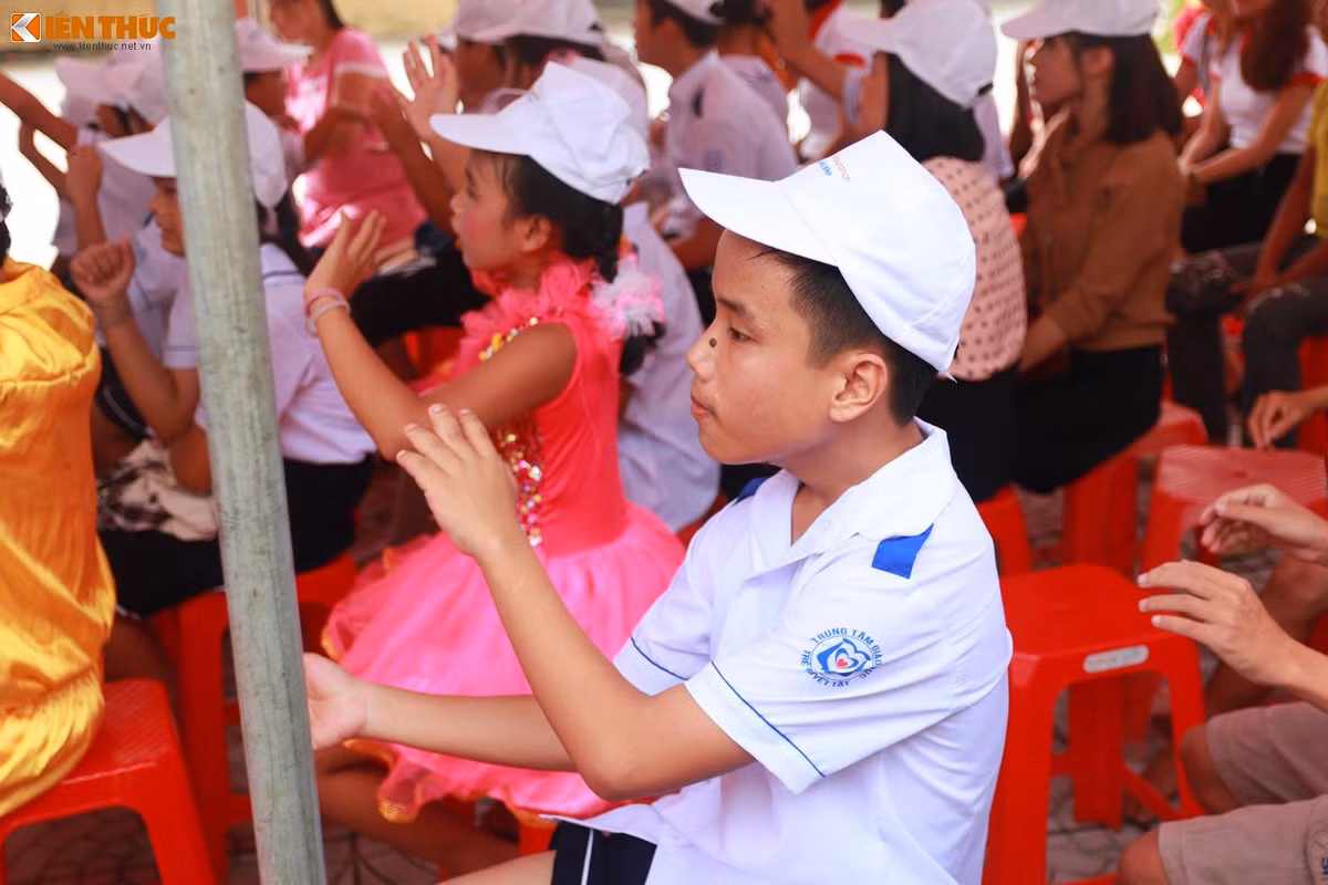 Một em thiểu năng trí tuệ đang cố gắng làm theo những động tác múa của các bạn trên sân khấu. Ảnh: Quốc Minh.