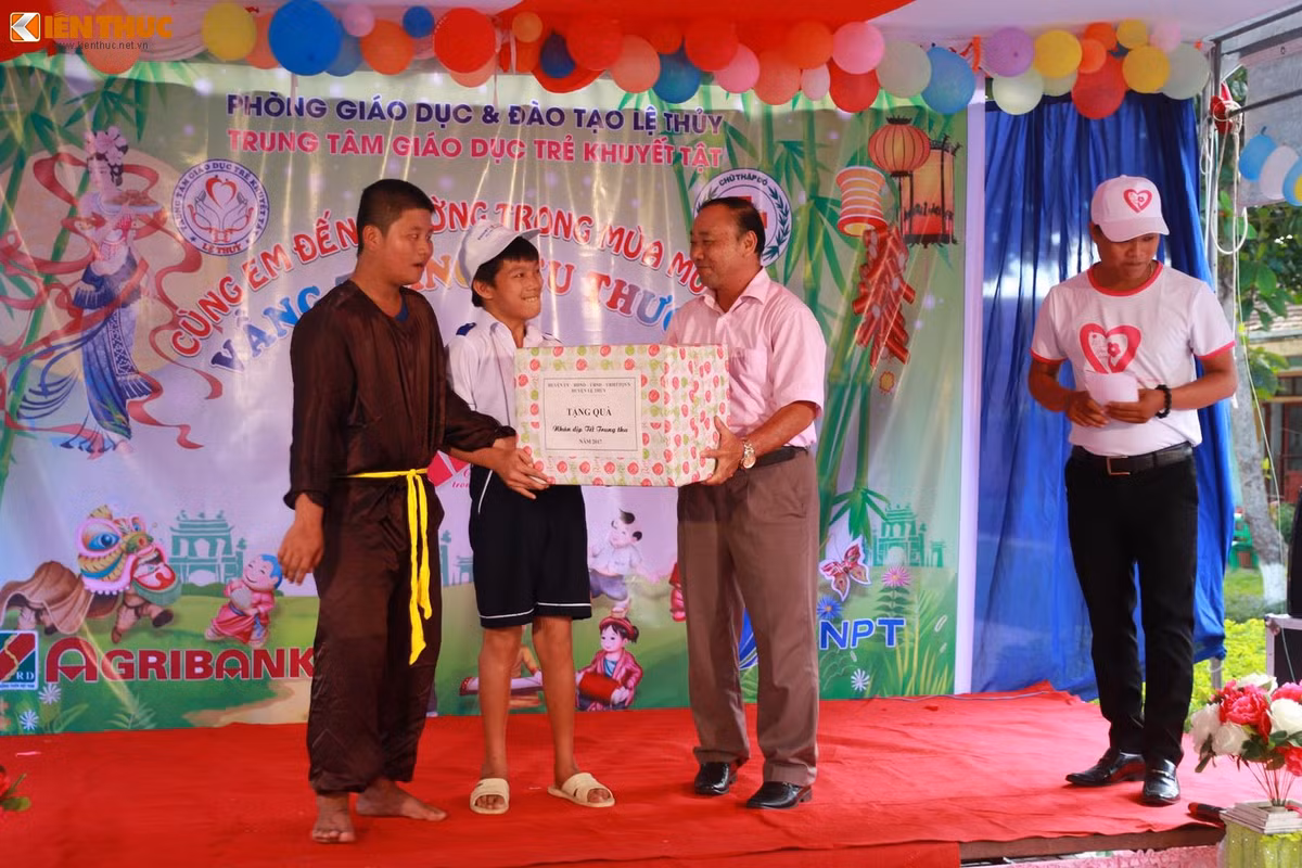 Đại diện lãnh đạo huyện Lệ Thủy trao quà cho các em khuyết tật có hoàn cảnh đặc biệt khó khăn. Ảnh: Quốc Minh.