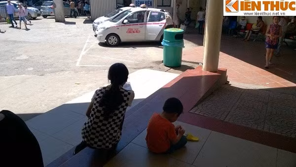 Hai mẹ con bệnh nhi ngao ngán nhìn trời nắng sau khi khám bệnh.