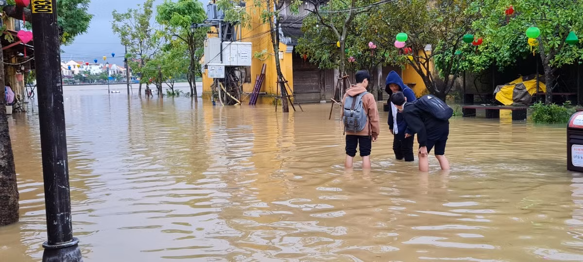 Khu vực ven sông Hoài nước ngập ngang bắp chân. Học sinh tan học phải lội về nhà.