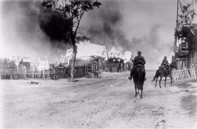 Kỵ binh Đức di chuyển cạnh ngôi làng đang bốc cháy gần Mohylev, ngày 16/7/1941. Nguồn ảnh: Washington History Online