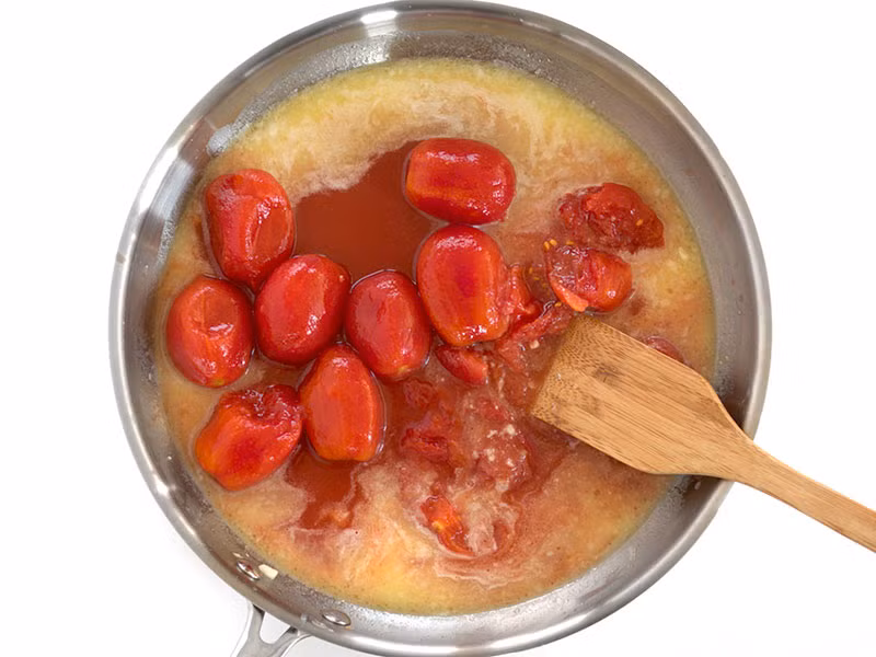 Cho cà chua bóc vỏ vào xào chung, rắc thêm một ít ớt bột. Dùng thìa to hoặc phớt lồng dầm cà chua thành miếng nhỏ. Tiếp tục để cà chua sôi lăn tăn trên bếp, thỉnh thoảng đảo qua cho đến khi sốt cà chua nhuyễn và sánh lại. Thời gian nấu khoảng 30 phút.
