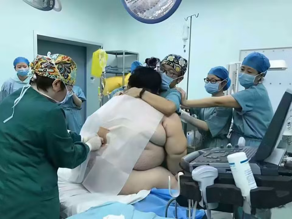 Bà bầu béo phì người Trung Quốc được giấu danh tính này đang được rất nhiều chuyên gia, gồm có bác sĩ khoa sản, bác sĩ phụ khoa, bác sĩ khoa nhi, bác sĩ gây mê cùng các y tá, vây quanh và tất cả đều đang cố gắng hết sức để giữ thăng bằng vì sản phụ quá nặng cân. 