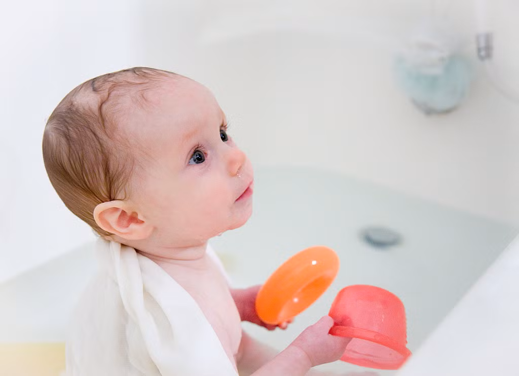 Pha dầu dừa vào nước tắm của bé để bé không bị khô da.