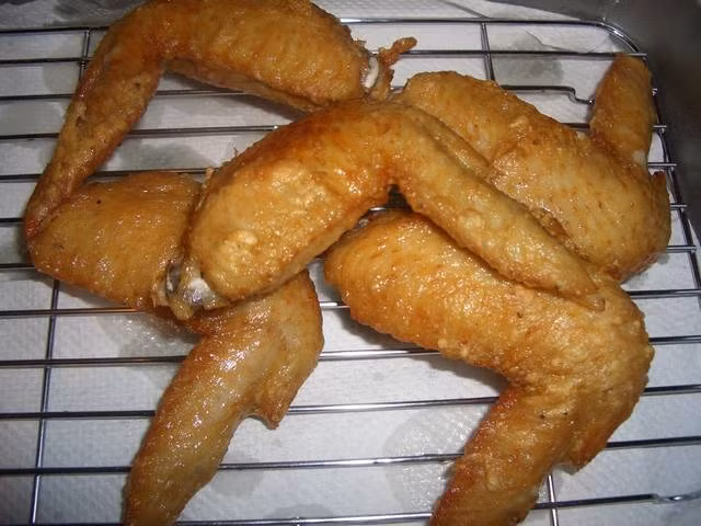 Cho dầu vào chảo, bật bếp làm nóng dầu đến khoảng 107 độ C rồi cho cánh gà vào chiên trong khoảng 6-8 phút. Lúc này gà đã gần chín hết. 