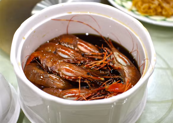 Món ăn với tên gọi “tôm say” của Trung Quốc này không cần nấu mà chỉ đơn giản là tôm sạch còn sống thả vào trong rượu trắng rồi tự chín. 