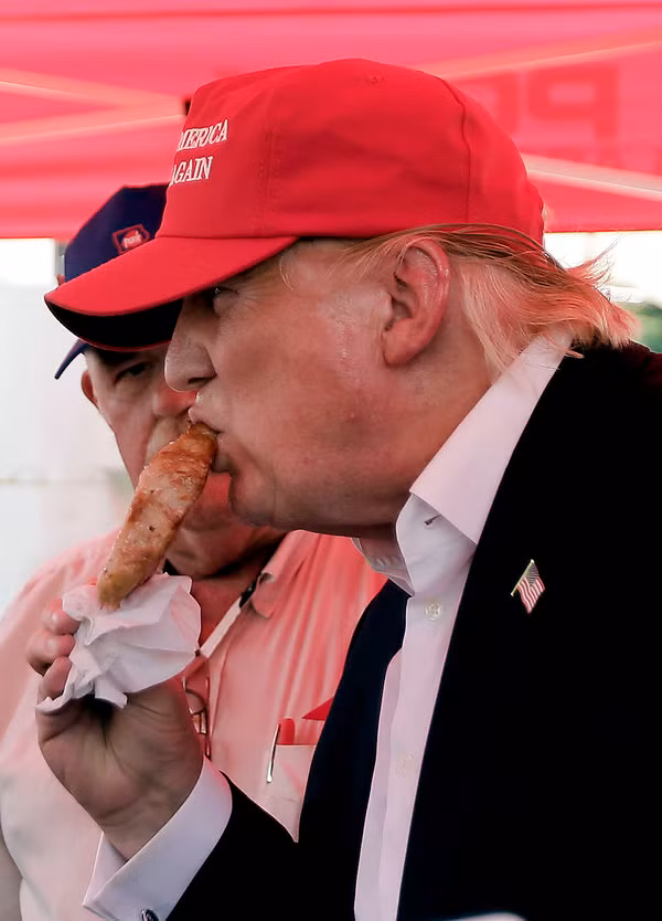 Tại một hội chợ, ông Trump trông có vẻ đang tận hưởng món thịt lợn xiên que này. Được biết suốt từ năm 1985 thì chưa ai có thể chụp ảnh ông ăn đồ ăn bằng tay, thậm chí đối với món bánh pizza thì ông còn ăn bằng dĩa. (Nguồn ảnh: Huffpost) 