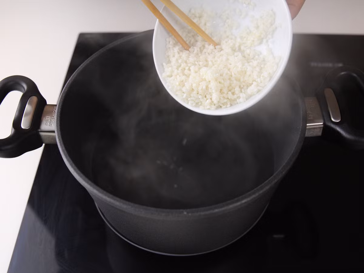 Lấy một lượng nước vừa đủ, đun sôi lên rồi cho gạo vào nấu cháo đến khi hạt gạo mềm nở bung ra.