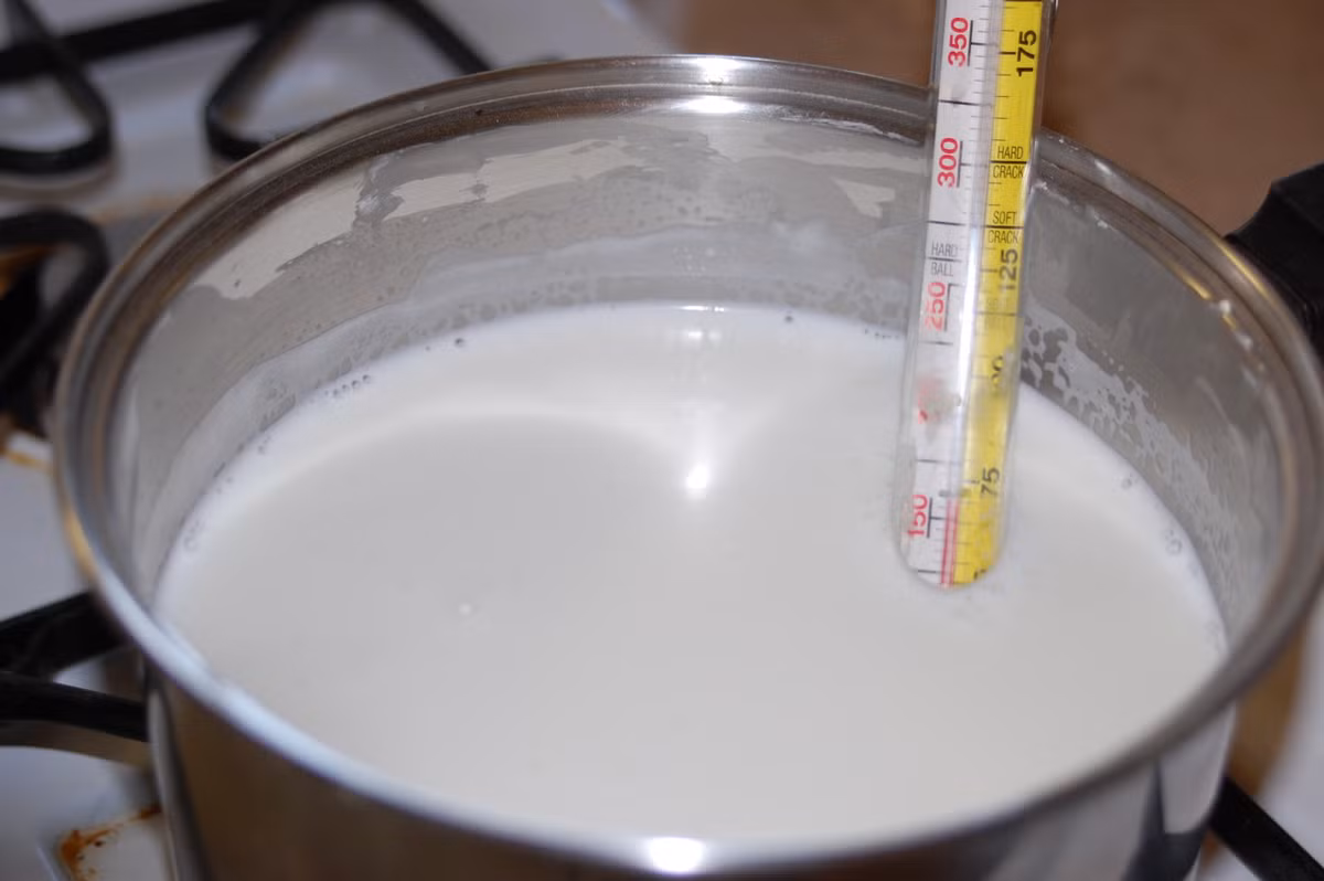 Đầu tiên pha lượng sữa bạn cần rồi đun hỗn hợp này đến khoảng 47-50 độ C. Lấy riêng một cốc sữa từ phần sữa đã làm nóng, cho bột gelatin vào để khuấy tan rồi đổ trở lại. Để cho sữa hạ xuống khoảng 43 độ C thì cho men vào và khuấy đều. 