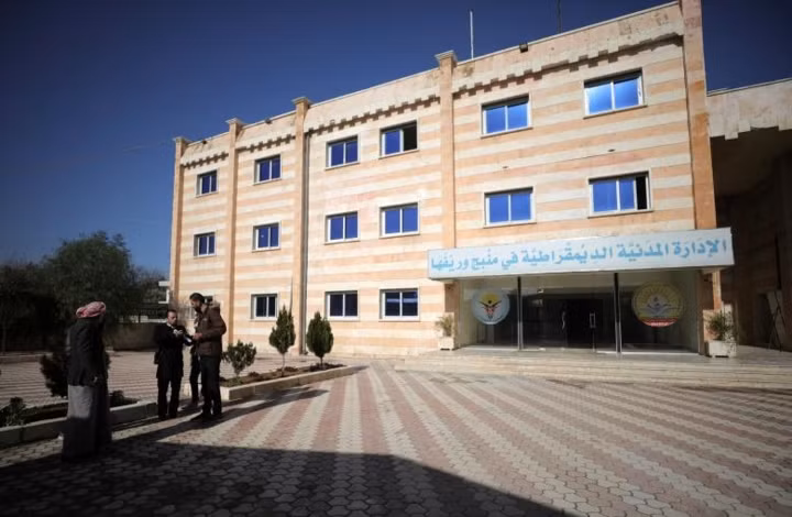 IS bị đánh bại ở Manbij năm 2016 bởi Các lực lượng Dân chủ Syria (SDF) - lực lượng chủ yếu là dân quân người Kurd (YPG) và được liên minh do Mỹ dẫn đầu hậu thuẫn. Ảnh: Một tòa nhà hành chính dân sự của Manbij.