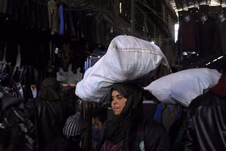 Manbij đã "đổi chủ" 3 lần kể từ khi cuộc xung đột ở Syria bùng phát năm 2011. Quân đội Syria Tự do đã chiếm thành phố này từ lực lương chính phủ, nhưng sau đó lại để mất vào tay IS. Ảnh: Một phụ nữ đang đội bao tải trên đầu ở một khu chợ của Manbij.