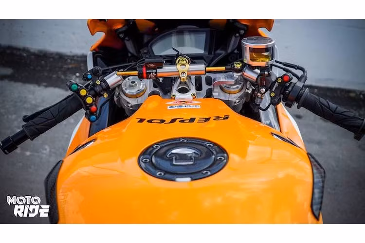 Ở khu vực tay lái của chiếc CBR1000RR cũng là hàng loạt các món đồ chơi khác nhau. Nằm giữa chảng ba trên là cây trợ lực Matris giúp ổn định phần đầu khi ở tốc độ cao, trong khi chính chảng ba cũng đã được thay thế bằng loại nhôm CNC đục lỗ cứng cáp và nhẹ hơn.