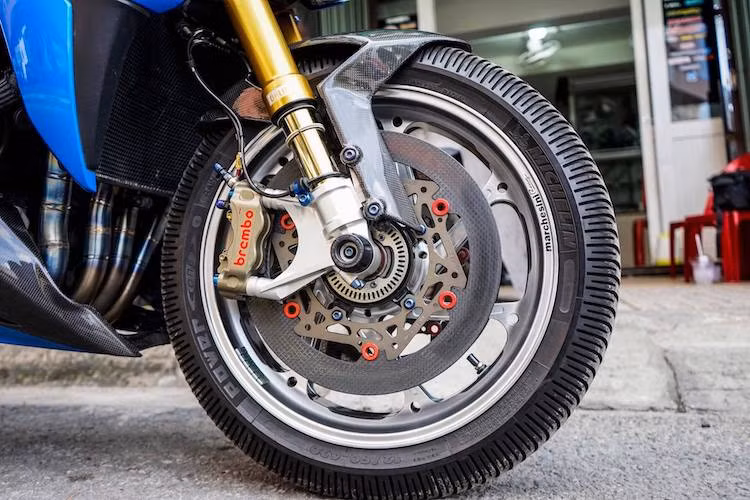 "Dàn chân" phía trước của chiếc xe đã được độ lại khá "khủng" với cặp phuộc Ohlins FGRT 201 đạt chuẩn xe đua WSBK, cùng với hệ thống phanh gồm toàn "hàng hiệu" với cặp heo Brembo HP Billet 4 piston và đĩa phanh Braketech sợi carbon. Phần "mỏ cày" ốp dưới gầm và chắn bùn trước của xe cũng được thay bằng sợi carbon.