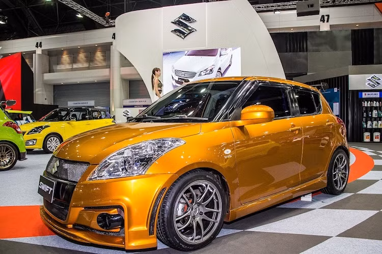 Một bản độ Swift khá "ngầu" với cản trước "hàng thửa" theo phong cách thể thao, màu sơn cam ánh kim bắt mắt và bộ mâm Work Emotion CR Kai mạ chrome "long lanh".