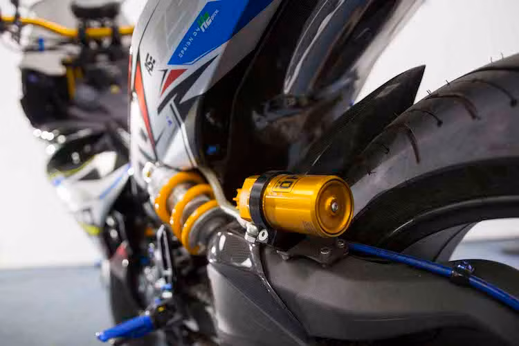 Bên cạnh gắp, hệ thống phuộc sau của xe cũng được độ lại bằng loại Ohlins bình dầu rời. Tuy nhiên do xe đã thay gắp đơn của Ducati nên điểm bắt phuộc trên khung cũng đã buộc phải chế lại, đặt lệch sang bên trái thay vì nằm chính giữa như Exciter 150 nguyên bản.
