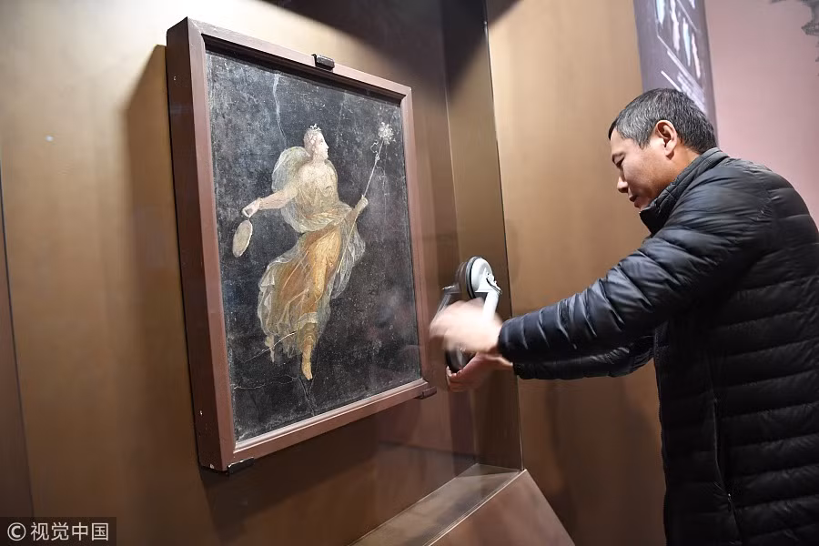 Loạt cổ vật được khai quật ở Pompeii, thành phố cổ bị xóa sổ hoàn toàn khi núi lửa Vesuvius phun trào dữ dội năm 79 trước Công nguyên. Toàn bộ người dân, nhà cửa, đường xá... bị chôn vùi trong lớp tro bụi núi lửa dày 4 - 6m. Trong ảnh là nhân viên bảo tàng sắp xếp một bức tranh của người La Mã thời cổ đại.