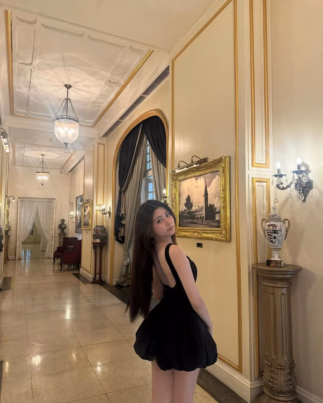 Cô nàng lựa chọn chiếc váy ngắn màu đen có phần chân váy bồng, tinh tế khoe bờ vai trần gợi cảm cùng vòng eo thon gọn.