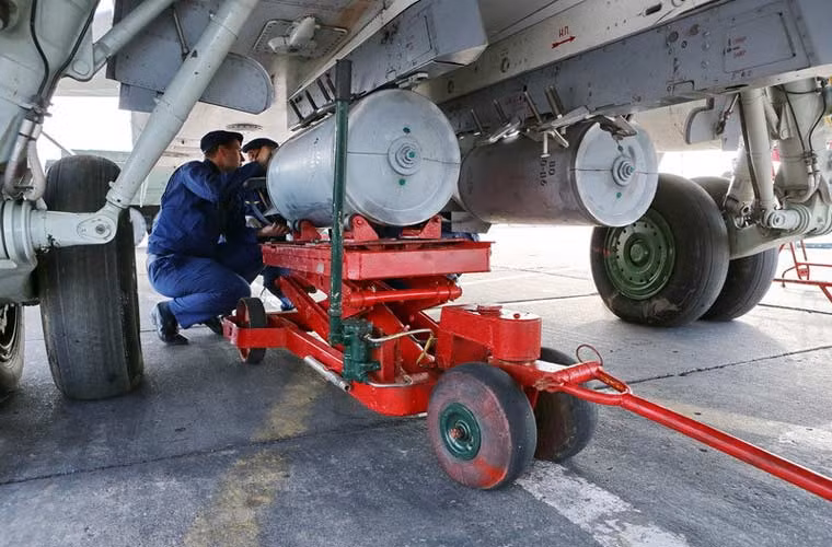 Trong ảnh, các kĩ thuật viên không quân Nga đang lắp quả bom lên giá treo bụng máy bay cường kích Su-24 tham gia cuộc tập trận Center-2015 diễn ra từ ngày 25/5 với sự tham gia của 12.000 quân cùng 250 máy bay các loại.