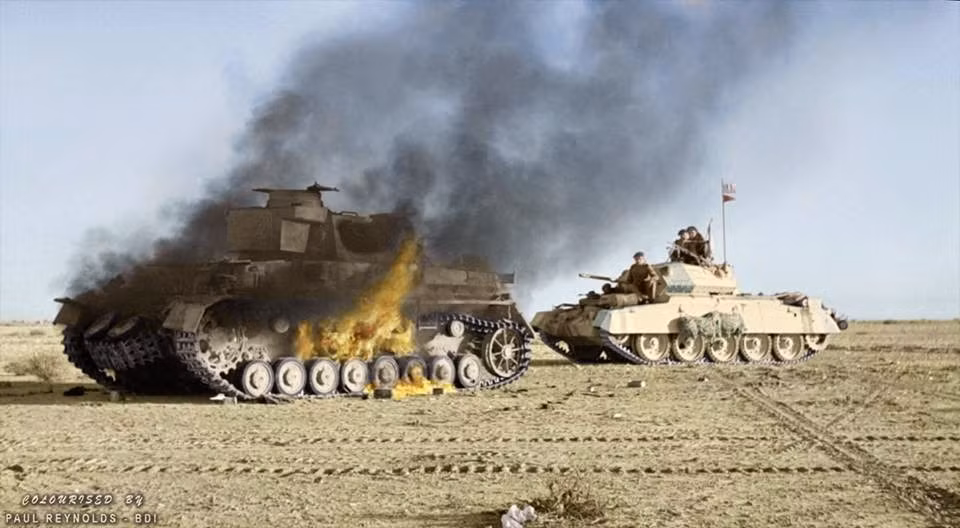 Một chiếc xe tăng Crusader của Anh đi qua một chiếc xe tăng Đức Panzer IV đang cháy trong Chiến dịch Crusader ở phía Đông Libya, mùa đông năm 1941. Ảnh: Vintag.