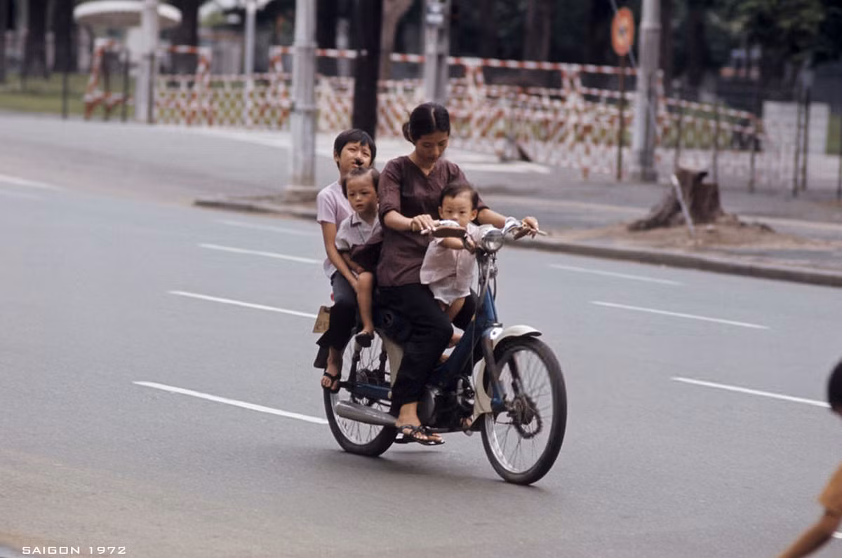 Bà mẹ trẻ chở ba đứa con nhỏ trên chiếc xe gắn máy. Ảnh: Patrice Habans.