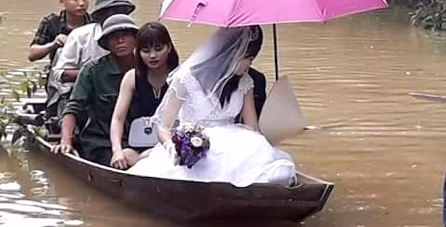 Không đi bộ, đi xe được vì nước ngập vào tháng 10 vừa qua, cặp đôi ở huyện Hương Khê, tỉnh Hà Tĩnh đã đi thuyền trong ngày cưới.