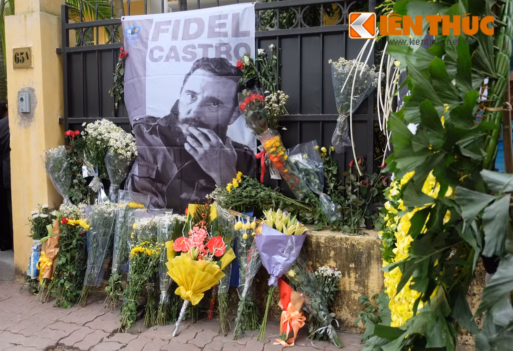 Những lẵng hoa, bó hoa tưởng niệm... được đặt cạnh bức hình nhà lãnh tụ Cuba Fidel Castro bên ngoài Đại sứ quán. Đại sứ quán Cuba tại Hà Nội mở sổ tang tưởng niệm lãnh tụ Fidel Castro từ ngày 28/11-4/12.