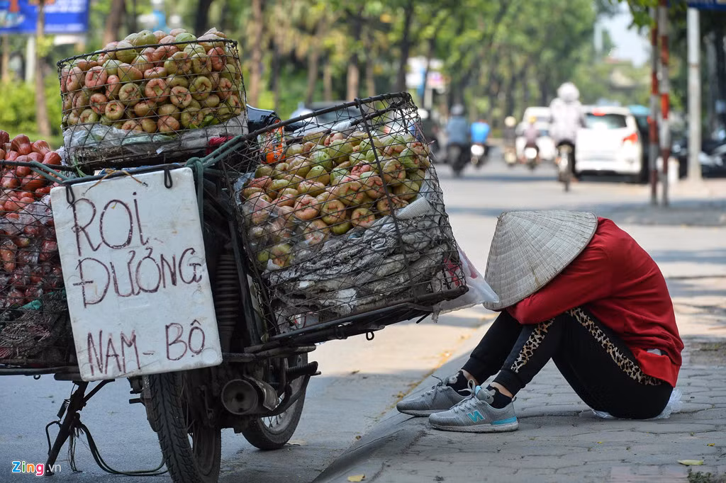 Chị bán hàng rong ngủ gục lúc 14h trên đường Hoàng Quốc Việt. Tuy ở trong bóng râm, nhưng hơi nóng phả từ mặt đường lên vẫn rất khó chịu.